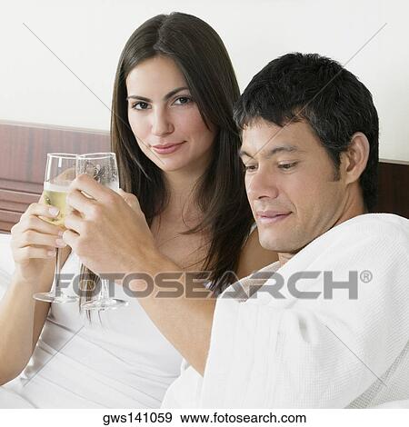 Portrait of a young woman and a mid adult man toasting with champagne flutes View Large Photo Image Stock Photo - Portrait of a young woman and a mid adult man toasting with champagne flutes. Fotosearch