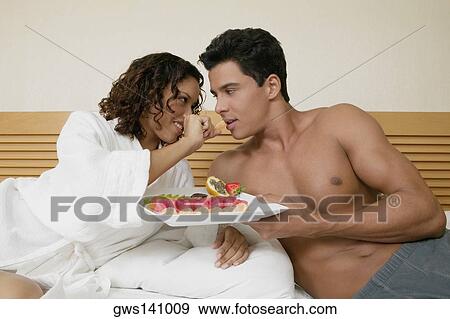 Teenage girl feeding a young man an orange View Large Photo Image Stock Photo - Teenage girl feeding a young man an orange. Fotosearch