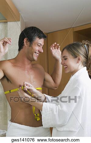 Young woman measuring a mid adult man's chest with a tape measure View Large Photo Image Stock Photograph - Young woman measuring a mid adult man's chest with a tape measure. Fotosearch