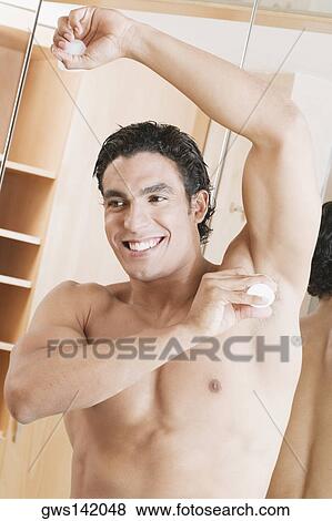 Close-up of a young man applying deodorant under his arm View Large Photo Image Stock Photo - Close-up of a young man applying deodorant under his arm. Fotosearch