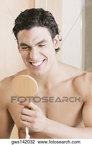 Close-up of a young man looking into a mirror View Large Photo Image Stock Image - Close-up of a young man looking into a mirror. Fotosearch