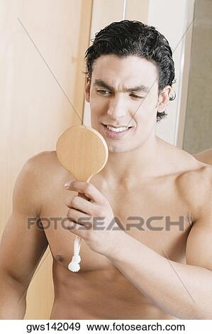 Close-up of a young man looking into a mirror View Large Photo Image Stock Photo - Close-up of a young man looking into a mirror. Fotosearch