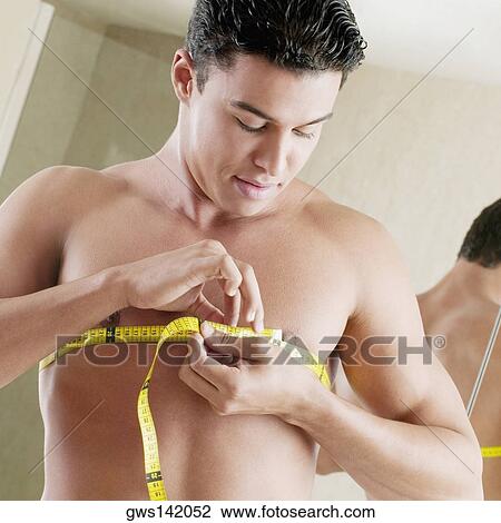 Close-up of a young man measuring his chest with a tape measure View Large Photo Image Stock Image - Close-up of a young man measuring his chest with a tape measure. Fotosearch