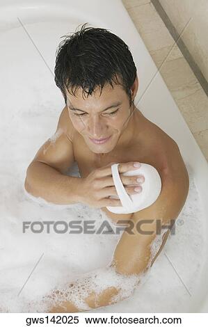 High angle view of a mid adult man scrubbing his body with a loofah in a bathtub View Large Photo Image Stock Photography - High angle view of a mid adult man scrubbing his body with a loofah in a bathtub. Fotosearch