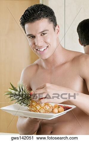 Portrait of a young man holding a plate of fruit View Large Photo Image Stock Image - Portrait of a young man holding a plate of fruit. Fotosearch