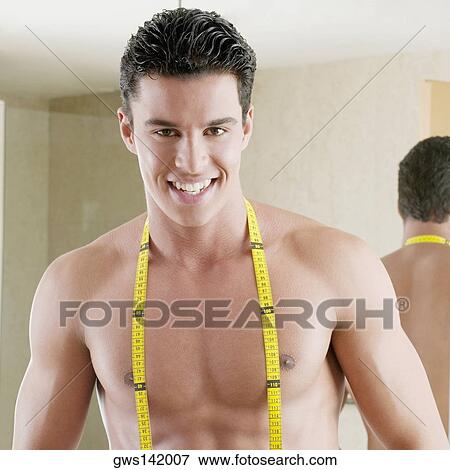 Stock Photo - Portrait of a young man with a tape measure around his neck. Fotosearch