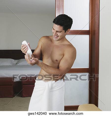 Young man squeezing a bottle of moisturizer on his palm View Large Photo Image Stock Image - Young man squeezing a bottle of moisturizer on his palm. Fotosearch