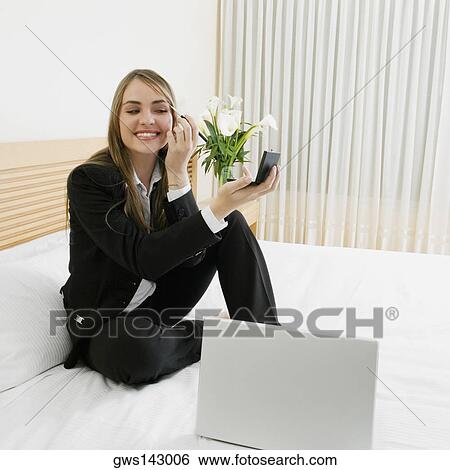 Businesswoman applying eyeshadow on her eyes with a laptop in front of her View Large Photo Image Stock Photograph - Businesswoman applying eyeshadow on her eyes with a laptop in front of her. Fotosearch