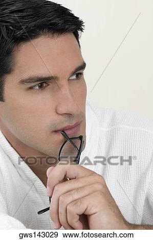 Close-up of a young man thinking View Large Photo Image Stock Photo - Close-up of a young man thinking. Fotosearch