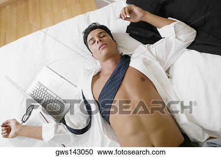 High angle view of a businessman sleeping on the bed View Large Photo Image Stock Image - High angle view of a businessman sleeping on the bed. Fotosearch