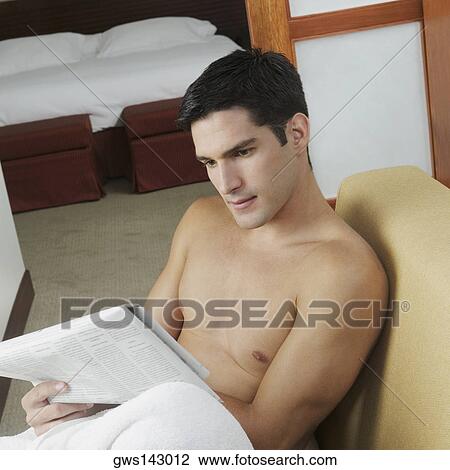 High angle view of a young man reading a newspaper View Large Photo Image Stock Image - High angle view of a young man reading a newspaper. Fotosearch