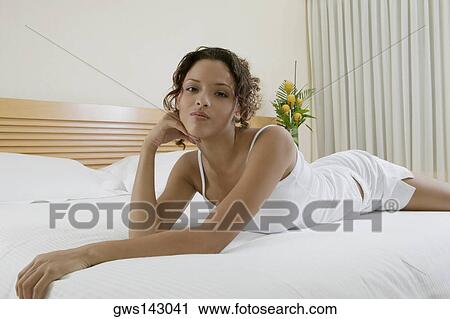 Portrait of a young woman lying on the bed View Large Photo Image Stock Image - Portrait of a young woman lying on the bed. Fotosearch