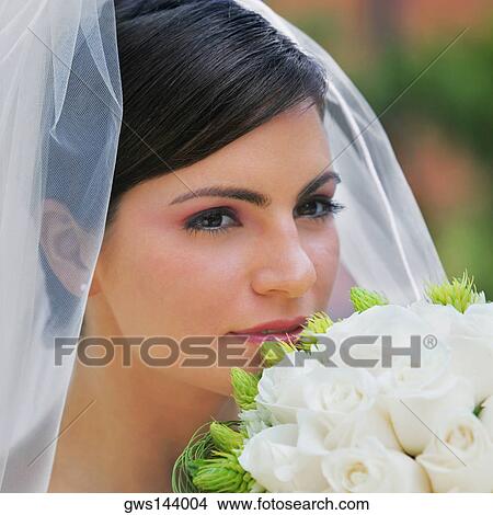 Close-up of a bride smelling a bouquet of flowers View Large Photo Image Picture - Close-up of a bride smelling a bouquet of flowers. Fotosearch