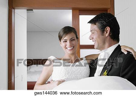 Groom carrying his bride and smiling View Large Photo Image Stock Photograph - Groom carrying his bride and smiling. Fotosearch