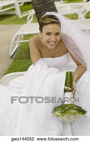 Portrait of a bride holding a bouquet of flowers and smiling View Large Photo Image Stock Image - Portrait of a bride holding a bouquet of flowers and smiling. Fotosearch