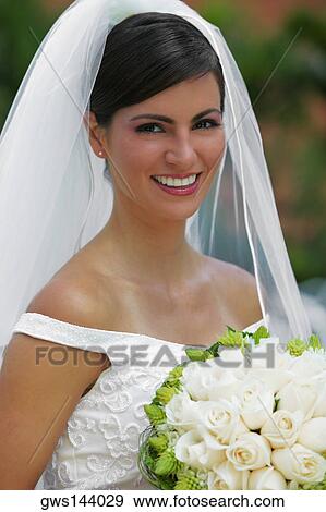 Portrait of a bride holding a bouquet of flowers and smiling View Large Photo Image Stock Photo - Portrait of a bride holding a bouquet of flowers and smiling. Fotosearch