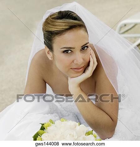 Portrait of a bride sitting with her hand on her chin View Large Photo Image Stock Photo - Portrait of a bride sitting with her hand on her chin. Fotosearch