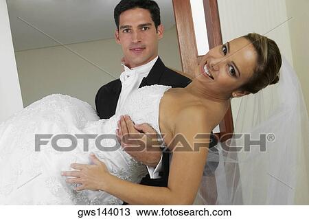 Portrait of a groom carrying his bride View Large Photo Image Stock Image - Portrait of a groom carrying his bride. Fotosearch
