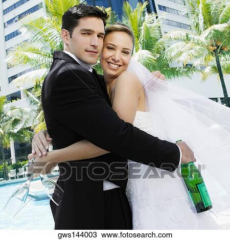 Portrait of a newlywed couple embracing each other View Large Photo Image Stock Image - Portrait of a newlywed couple embracing each other. Fotosearch