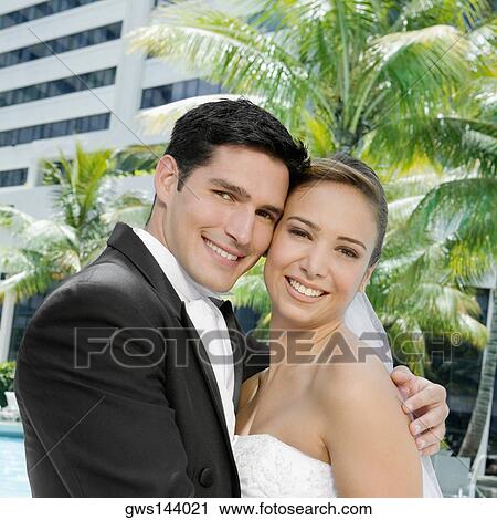 Portrait of a newlywed couple embracing each other View Large Photo Image Stock Image - Portrait of a newlywed couple embracing each other. Fotosearch