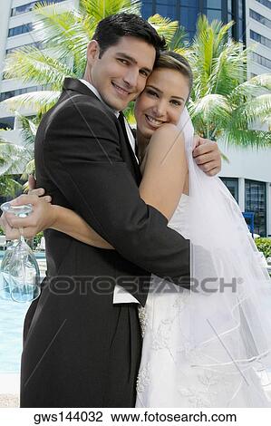 Portrait of a newlywed couple embracing each other View Large Photo Image Stock Image - Portrait of a newlywed couple embracing each other. Fotosearch