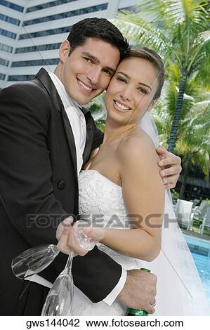 Stock Image - Portrait of a newlywed couple embracing each other. Fotosearch