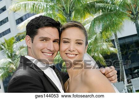 Portrait of a newlywed couple embracing each other View Large Photo Image Stock Image - Portrait of a newlywed couple embracing each other. Fotosearch