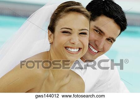 Portrait of a newlywed couple smiling View Large Photo Image Stock Image - Portrait of a newlywed couple smiling. Fotosearch
