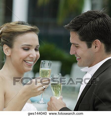 Side profile of a bride and her groom toasting with champagne flutes View Large Photo Image Stock Image - Side profile of a bride and her groom toasting with champagne flutes. Fotosearch