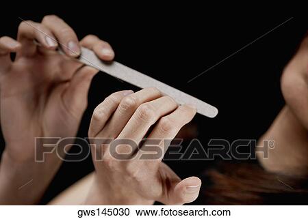 Close-up of a woman's hand filing her nails View Large Photo Image Stock Image - Close-up of a woman's hand filing her nails. Fotosearch