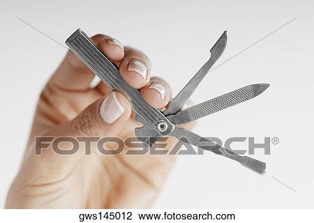 Stock Image - Close-up of a woman's hand holding a penknife. Fotosearch