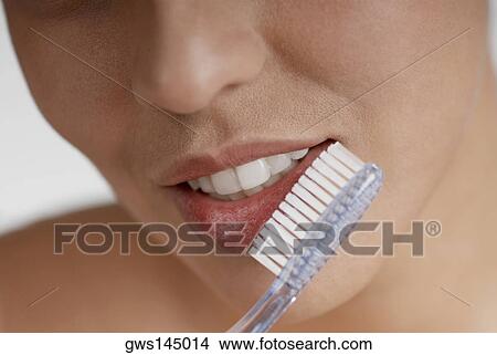 Close-up of a young woman brushing her teeth View Large Photo Image Picture - Close-up of a young woman brushing her teeth. Fotosearch