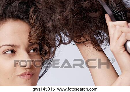 Stock Photography - Close-up of a young woman brushing her hair. Fotosearch