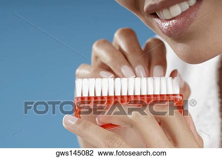 Close-up of a young woman cleaning her fingernails with a nail brush View Large Photo Image Stock Image - Close-up of a young woman cleaning her fingernails with a nail brush. Fotosearch