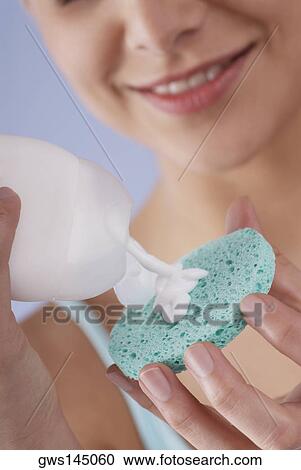 Close-up of a young woman pouring moisturizer on a sponge View Large Photo Image Stock Image - Close-up of a young woman pouring moisturizer on a sponge. Fotosearch