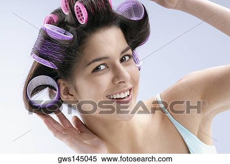 Close-up of a young woman putting curlers in her hair View Large Photo Image Stock Photography - Close-up of a young woman putting curlers in her hair. Fotosearch
