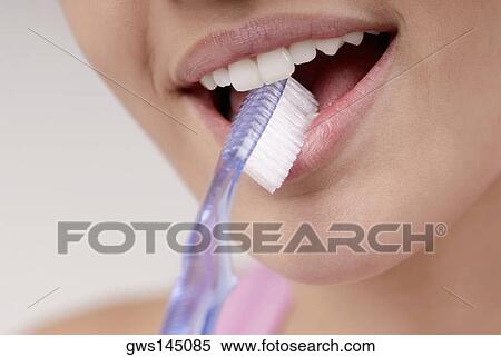 Close-up of a young woman with a toothbrush in her mouth View Large Photo Image Stock Photography - Close-up of a young woman with a toothbrush in her mouth. Fotosearch