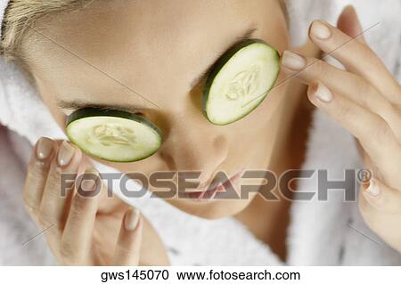 Close-up of a young woman with cucumber slices on her eyes View Large Photo Image Stock Image - Close-up of a young woman with cucumber slices on her eyes. Fotosearch