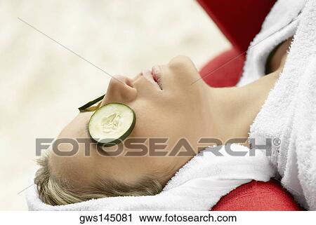 Close-up of a young woman with cucumber slices on her eyes View Large Photo Image Stock Image - Close-up of a young woman with cucumber slices on her eyes. Fotosearch