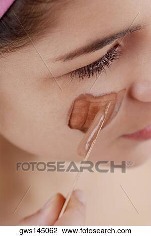 High angle view of a young woman applying a facial mask on her face View Large Photo Image Stock Image - High angle view of a young woman applying a facial mask on her face. Fotosearch