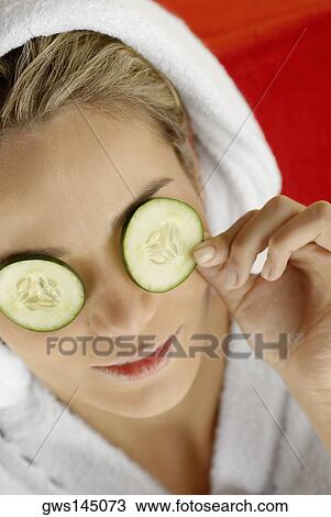 High angle view of a young woman resting with cucumber slices on her eyes View Large Photo Image Stock Image - High angle view of a young woman resting with cucumber slices on her eyes. Fotosearch