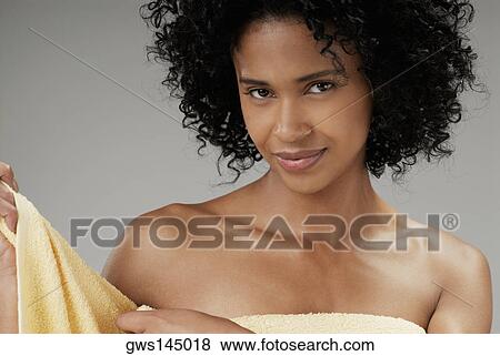 Portrait of a young woman adjusting a towel View Large Photo Image Stock Photo - Portrait of a young woman adjusting a towel. Fotosearch