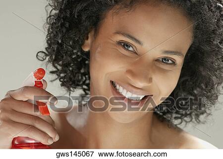 Portrait of a young woman holding a spray bottle View Large Photo Image Stock Photo - Portrait of a young woman holding a spray bottle. Fotosearch