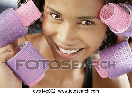 Portrait of a young woman holding curlers View Large Photo Image Stock Image - Portrait of a young woman holding curlers. Fotosearch