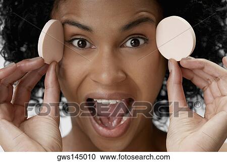 Portrait of a young woman holding powder puffs View Large Photo Image Stock Image - Portrait of a young woman holding powder puffs. Fotosearch