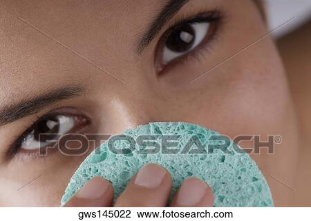 Portrait of a young woman scrubbing her nose with a sponge View Large Photo Image Stock Image - Portrait of a young woman scrubbing her nose with a sponge. Fotosearch