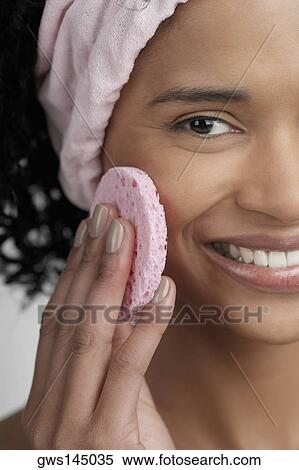 Portrait of a young woman using a powder puff View Large Photo Image Stock Photography - Portrait of a young woman using a powder puff. Fotosearch