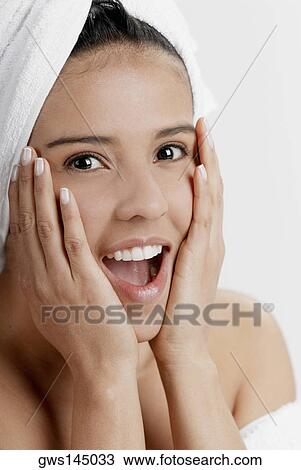 Portrait of a young woman with a towel wrapped around her head View Large Photo Image Stock Image - Portrait of a young woman with a towel wrapped around her head. Fotosearch