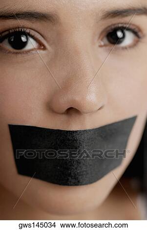 Portrait of a young woman with adhesive tape over her mouth View Large Photo Image Picture - Portrait of a young woman with adhesive tape over her mouth. Fotosearch