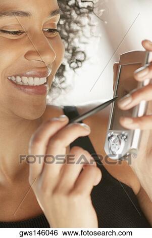 Close-up of a young woman holding a mobile phone and a stylus View Large Photo Image Stock Photograph - Close-up of a young woman holding a mobile phone and a stylus. Fotosearch